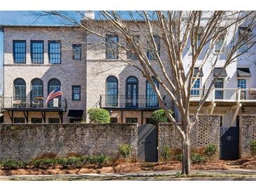 Charming brick townhome featuring a gated courtyard, balcony, and classic architectural details at 5705 Odell St, Cumming, GA 30040