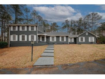 Charming two-story home with a landscaped yard, walkway, and gray siding and white shutters at 4995 Greentree Trl, College Park, GA 30349