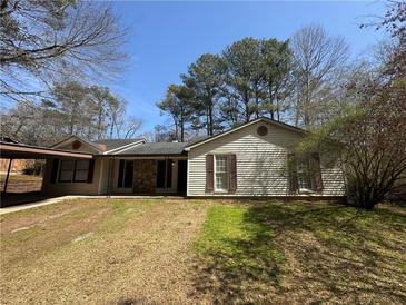 Charming single-story home featuring a cozy carport, stone accents, and mature trees at 5872 Fox Run, Rex, GA 30273