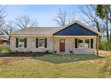 Charming brick home with a welcoming front yard, stone walkway, and dark shutters at 1246 Bell Ave, East Point, GA 30344