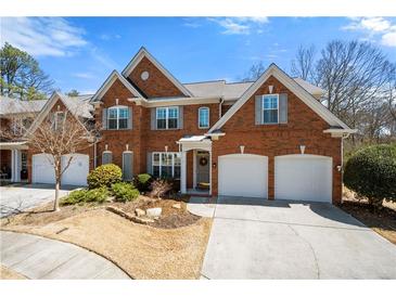 Charming brick home featuring a two-car garage, manicured lawn and traditional architectural details at 2330 Ventana Xing # 10, Marietta, GA 30062