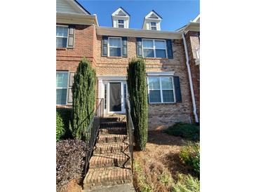 Brick townhome with dormer windows, front door and landscaped front with stairs at 4215 Wildener Way, Cumming, GA 30041