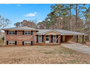 Charming brick home featuring a metal roof and covered carport on a sunny day at 4480 Highway 5, Douglasville, GA 30135