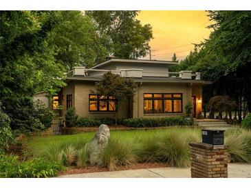 Charming brick home featuring a flat roof, meticulously landscaped front yard, and an inviting stone pathway, creating curb appeal at 1181 Fairview Ne Rd, Atlanta, GA 30306