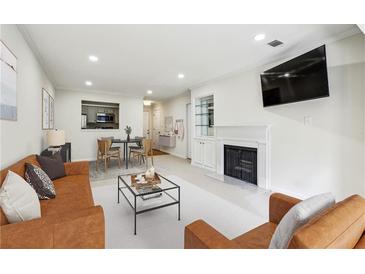 Bright living room features modern furniture, a fireplace, and an open view to the dining area and kitchen at 24308 Plantation Ne Dr, Atlanta, GA 30324