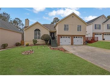 Charming split-level home with a manicured lawn, two-car garage, and inviting front entrance at 3135 Nectar Dr, Powder Springs, GA 30127