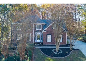 A charming two-story brick home with a landscaped front yard and mature trees at 2001 Towne Lake W Hls, Woodstock, GA 30189