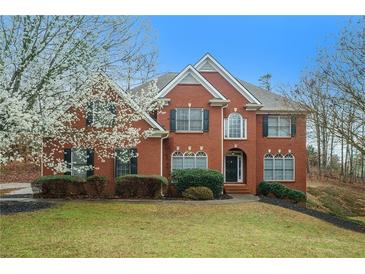 Charming red brick two-story home with manicured lawn and mature landscaping at 3502 Crown Peak Ct, Suwanee, GA 30024