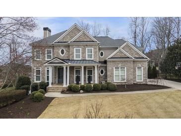 Stately two-story brick home with manicured landscaping, covered entryway and well-maintained lawn at 4325 Cody Ct, Cumming, GA 30040