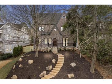 Charming brick home featuring a stone pathway, manicured landscaping, and beautiful architectural details at 239 E Wesley Ne Rd, Atlanta, GA 30305