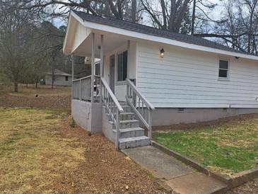 Charming single-story home featuring a cozy front porch with painted steps and a well-maintained yard at 136 Tye St, Stockbridge, GA 30281