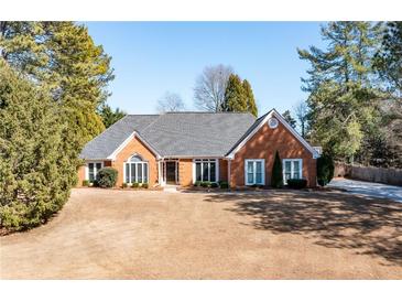 Charming single-story brick home with a well-manicured lawn and beautiful landscaping at 330 Todwick Dr, Roswell, GA 30075