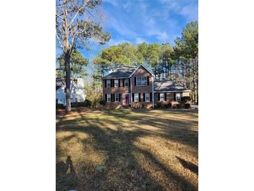 Traditional two-story home with a manicured lawn and a red front door at 9936 Point Vw, Jonesboro, GA 30238