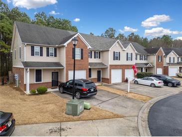 View of townhomes with brick and siding, driveway parking, well-maintained landscaping, and garage at 28 Eagle Glen Ne Dr, Cartersville, GA 30121