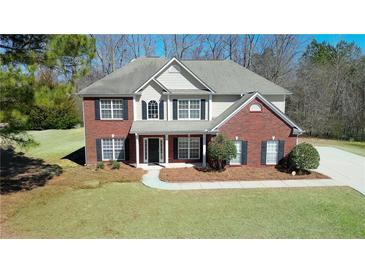 Charming two-story home with brick and siding exterior, complemented by a well-manicured lawn and landscaping at 30 Barbara Ct, Fayetteville, GA 30215