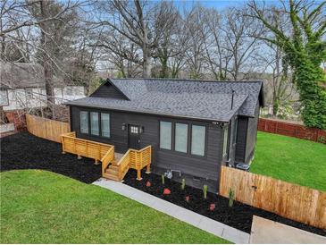 Charming exterior featuring a modern, dark facade, complemented by a well-manicured lawn and a wooden fence at 875 Center Hill Nw Ave, Atlanta, GA 30318