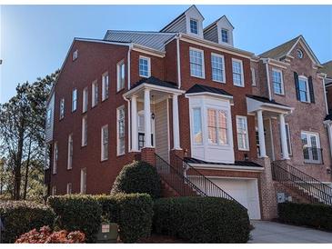 Charming brick townhome with a two-car garage and a beautifully landscaped front yard at 1272 Creekside Se Ter, Smyrna, GA 30082