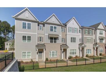 Attractive townhome exterior boasts manicured lawn, black fencing, and neutral color palette for modern appeal at 3348 Cranston Ln, Kennesaw, GA 30144