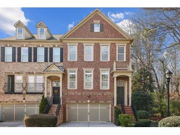 Charming brick townhome featuring a well-manicured front yard and an attached two-car garage at 1016 Parkmont Way, Decatur, GA 30033