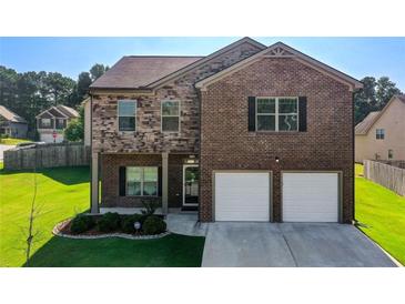 Beautiful two-story brick home featuring a well-manicured lawn and an attached two-car garage at 6101 Providence Way, Union City, GA 30291