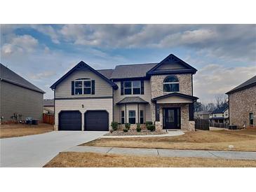 Beautiful two-story home with a brick and siding facade, two-car garage, and well-manicured lawn at 8103 White Oak Loop, Stone Mountain, GA 30038