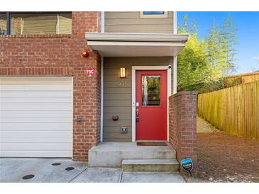 Inviting townhome entrance featuring a red door, brick accents, and modern design at 975 Moda Dr, Atlanta, GA 30316