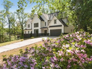 Beautiful two story home with white siding, black trim, gray garage, and beautiful landscaping in the front yard at 4201 Brookview Se Dr, Atlanta, GA 30339