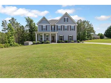 Charming two-story home featuring a well-manicured lawn and inviting curb appeal with a covered front porch at 8050 Tristan Way, Whitesburg, GA 30185
