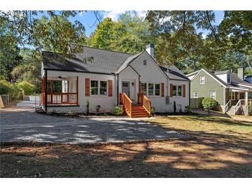 Charming white brick home with black roof, wood shutters, and covered porch at 985 Columbia Dr, Decatur, GA 30030