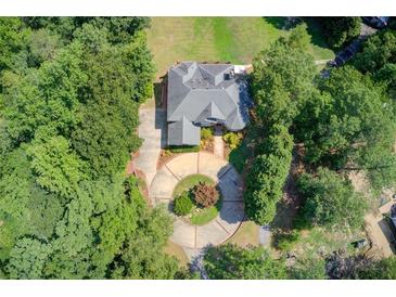 Stunning aerial view of a luxury home surrounded by lush landscaping and a circular driveway at 1603 Drowning Creek Rd, Dacula, GA 30019