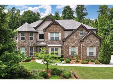 Beautiful two-story brick home showcasing manicured landscaping, and a blend of stone and siding at 2196 Abbott Dr, Buford, GA 30519