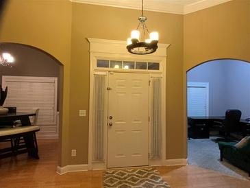 Inviting entryway with chandelier, transom window, and hardwood floors showcasing the home's style at 1162 Mason Lee, Loganville, GA 30052