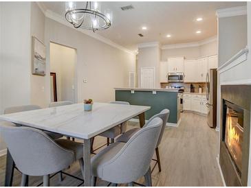 Open-concept dining room and kitchen with a marble table, modern light fixture, and stainless appliances at 1910 Cedar Glenn Way # 4401, Atlanta, GA 30339