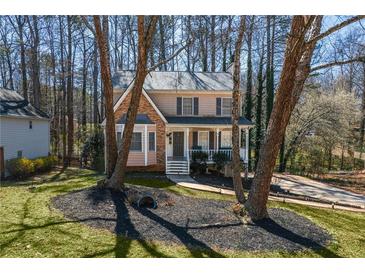 Charming two-story home with landscaped yard, front porch, and a combination of brick and siding at 23 Peggy Nw Ct, Marietta, GA 30064