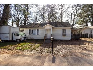 Modest single-story home with white siding and small front porch with a truck parked in front at 241 Killian St, Canton, GA 30114