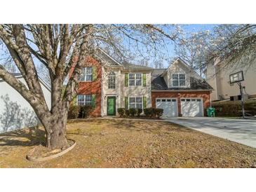 Charming two-story home with a brick and siding facade, green shutters, attached two-car garage, and mature trees at 5706 Spring Mill Cir, Lithonia, GA 30038