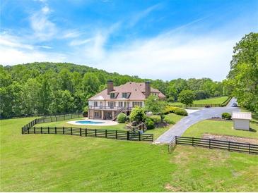 Expansive estate with luxurious home, private pool, and lush green pastures surrounded by mature trees at 714 Billings Farm Ln, Canton, GA 30115