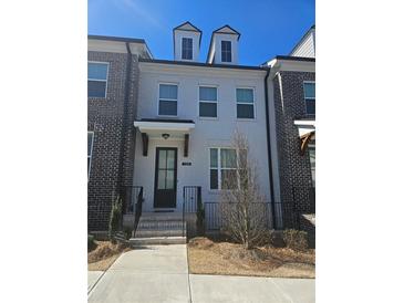 Charming three-story home featuring a well-manicured front yard and classic architectural details at 1309 Bennett Creek Ovlk, Suwanee, GA 30024