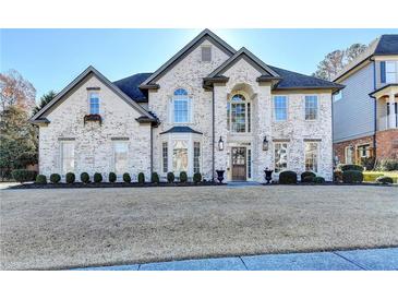 Stunning two-story brick home featuring a manicured lawn and symmetrical landscaping at 3350 Vista Creek Dr, Dacula, GA 30019