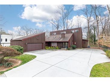 Unique two-story home with a stylish garage, modern driveway and mature landscaping at 1511 Womack Rd, Atlanta, GA 30338