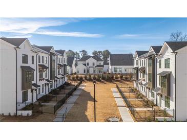 View of the new construction community featuring modern townhomes, sidewalks and landscaped common areas at 542 Healy Dr # 52, Cumming, GA 30040