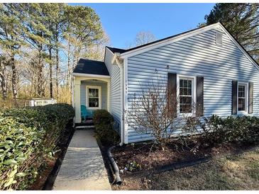 Charming single-story home with light blue siding, dark shutters, and a neatly landscaped front yard at 1395 W Booth Road Sw Ext, Marietta, GA 30008