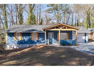 Charming blue one-story home boasts a covered porch and a single-car garage at 1981 Lindsey Ln, Decatur, GA 30035