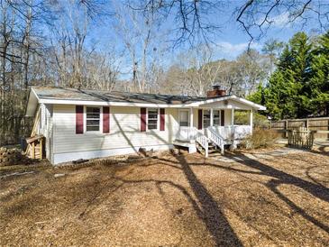 Charming single-story home with white siding, brick chimney, and a lovely front porch at 2570 Curtis Sw Rd, Marietta, GA 30064