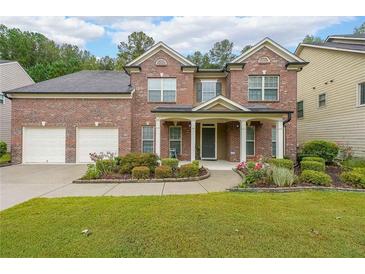 Beautiful two-story brick home featuring a manicured front lawn, a two-car garage, and a covered front porch at 4007 Fellowship Dr, Buford, GA 30519