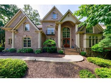 Charming two-story brick home featuring a well-manicured lawn and inviting entrance with arched windows at 1617 Windsor Ne Pkwy, Brookhaven, GA 30319