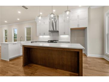 Bright kitchen with stainless steel appliances, wooden island, and elegant globe pendant lights at 169 Wards Crossing Way # 125, Johns Creek, GA 30022