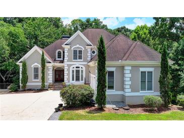 Charming two-story home with a well-maintained lawn, mature trees, and a welcoming front entrance at 4580 Lakefield Bend Bnd, Berkeley Lake, GA 30096
