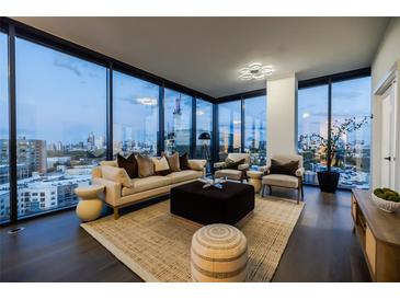 Modern living room featuring floor-to-ceiling windows and a comfortable seating arrangement with city views at 788 W Marietta Nw St # 1302, Atlanta, GA 30318