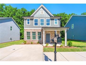 Charming two-story home with brick and gray siding, covered porch, and well-manicured front lawn at 1947 Thomasville Estate Dr, Atlanta, GA 30315